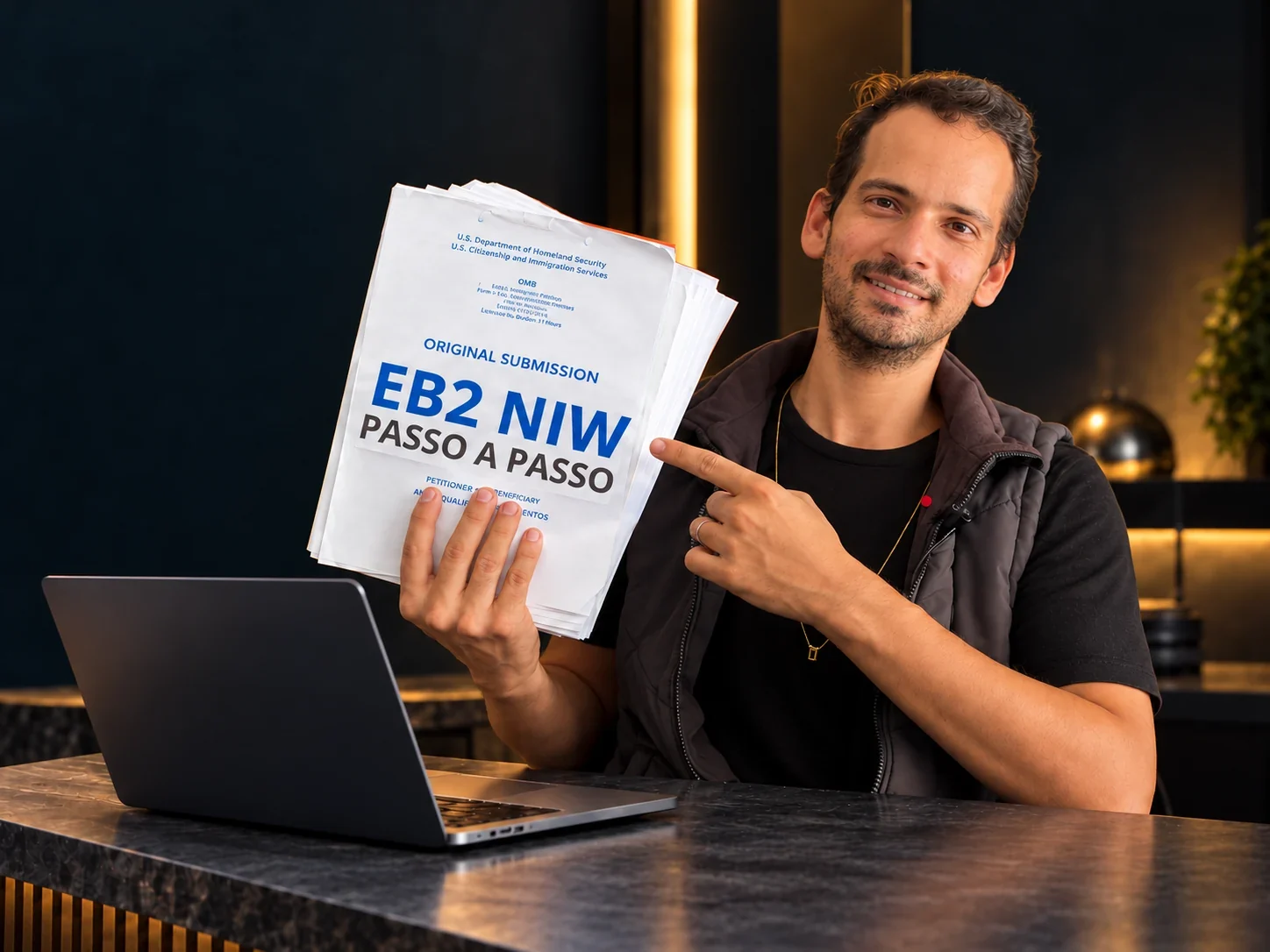Thiago Mait segurando sua petição EB2 NIW, ao lado de um notebook.